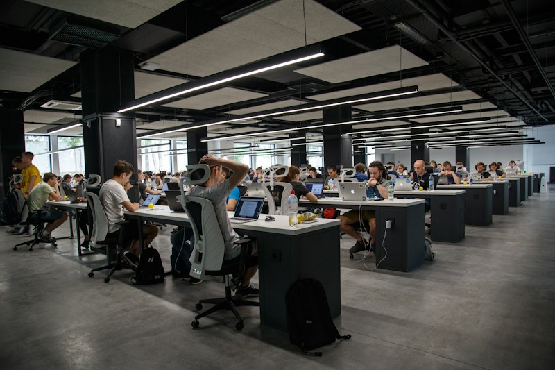 Fragmentos de dados digitais flutuando ao redor de um logotipo de startup quebrado, sendo coletados por braços robóticos, simbolizando a aquisição de dados de empresas falidas por laboratórios de IA.